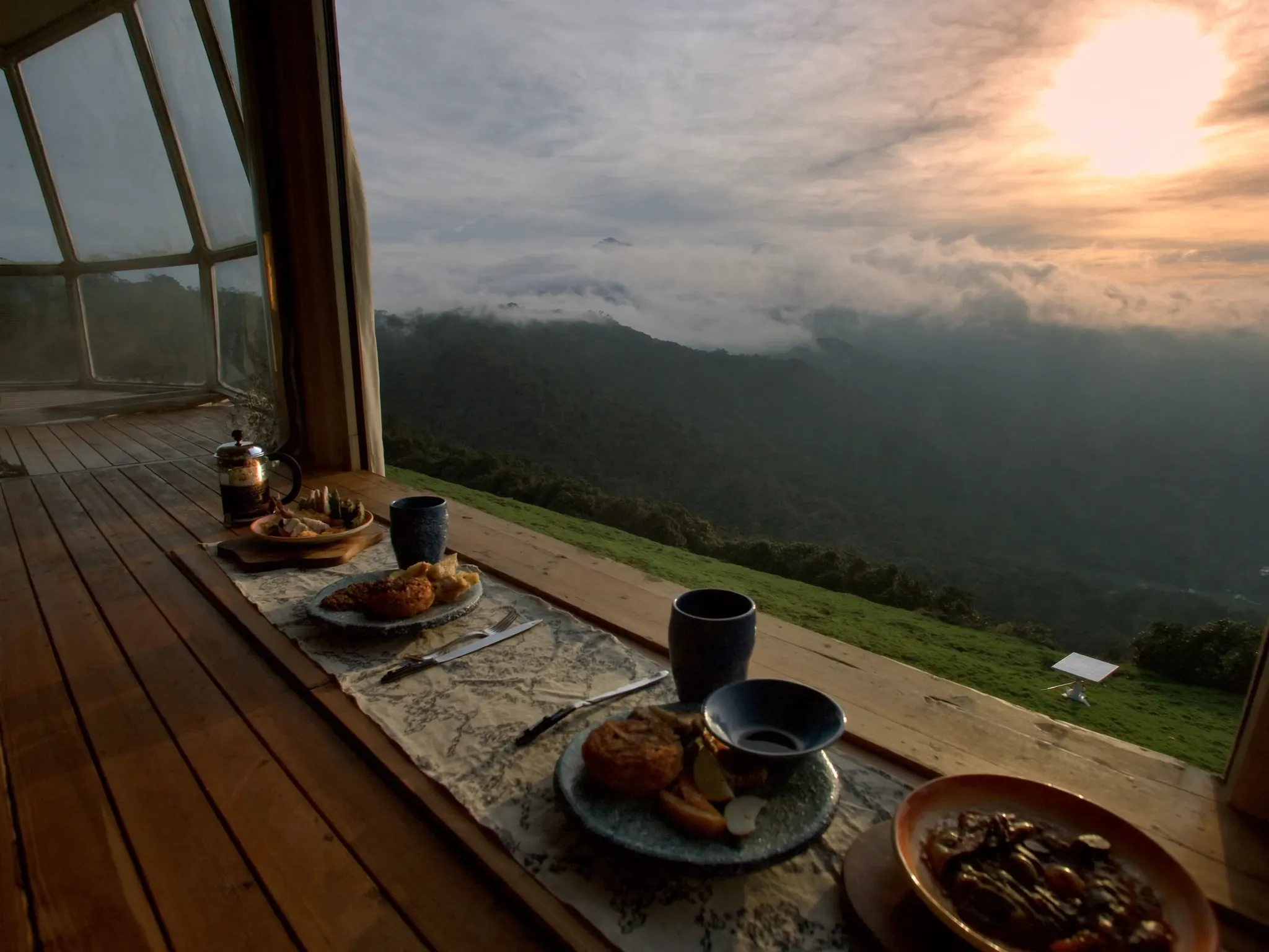 Desayuno en la terraza frente al valle cubierto de nubes.