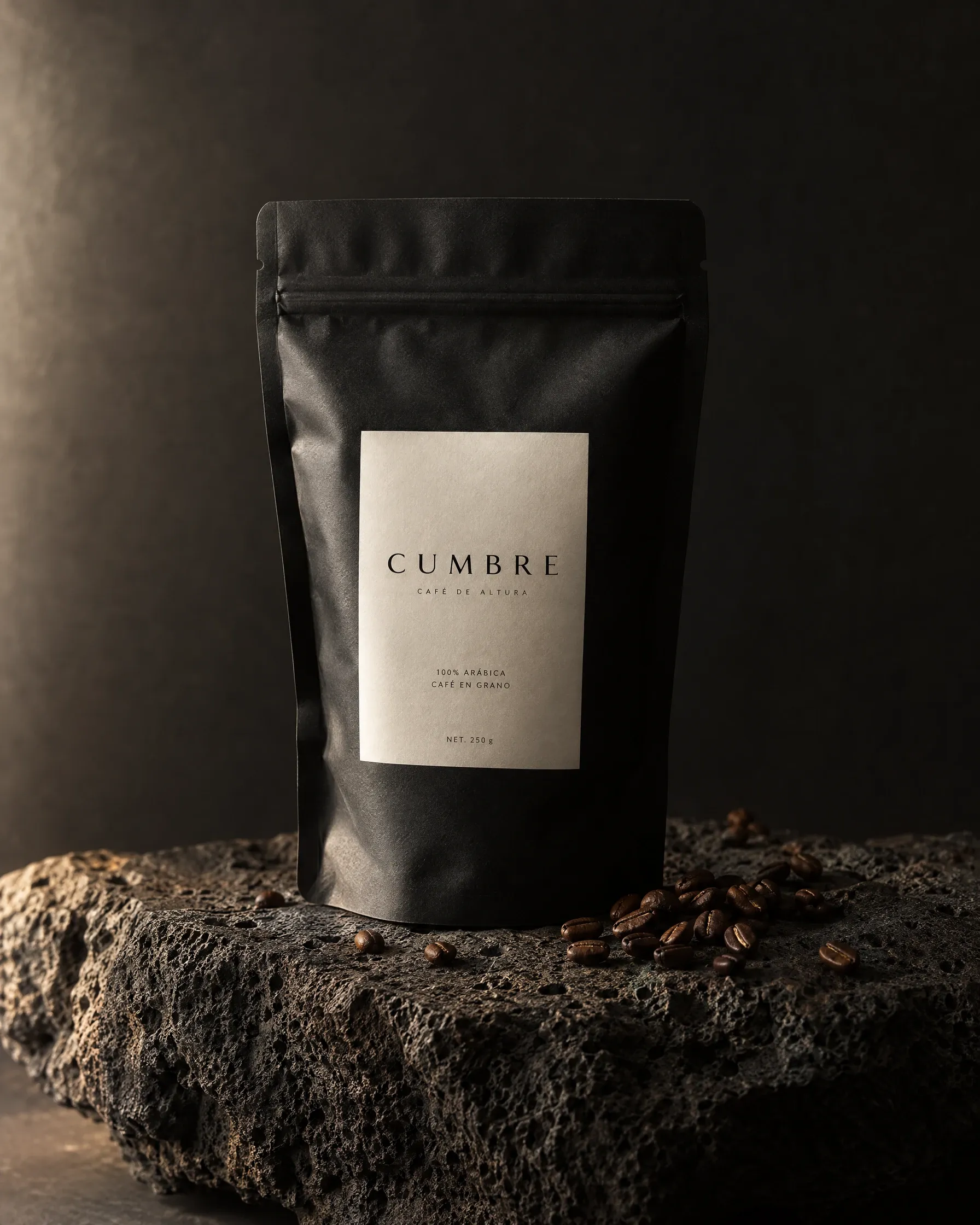 Bolsa negra de café Cumbre sobre una piedra volcánica.